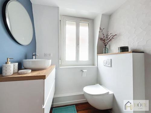 a bathroom with a sink and a toilet and a mirror at Élégance Malouine - 500m Plage in Dunkerque