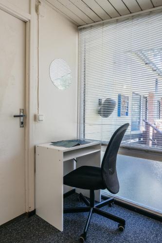 an office with a desk with a chair and a window at Kastytis in Nida