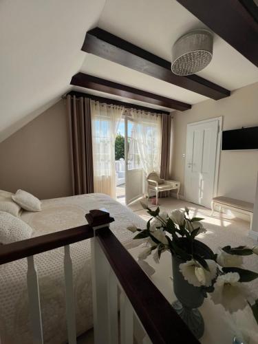 ein Schlafzimmer mit einem Bett und einer Vase mit Blumen in der Unterkunft Bay Cottage wynajem domków in Swarzewo