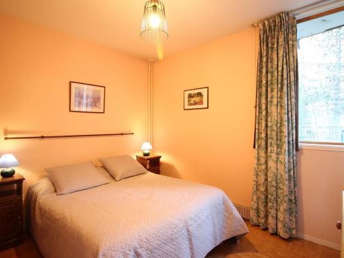 une chambre avec un lit et une fenêtre dans l'établissement T2 avec balcon, parking, wifi à 300m centre Mont-Dore - FR-1-608-130, à Le Mont-Dore