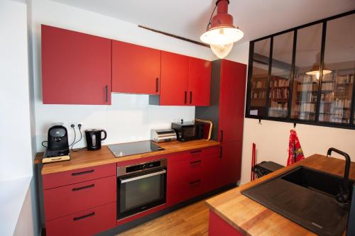 une cuisine avec des armoires rouges et un évier dans l'établissement Apt luxueux avec une vue splendide, à Eymet
