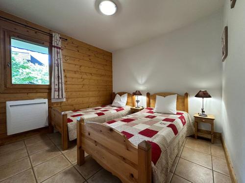 une chambre avec deux lits et une fenêtre dans l'établissement Appartement de Standing en Centre-Ville, Calme et Confort à Samoëns - FR-1-624-31, à Samoëns