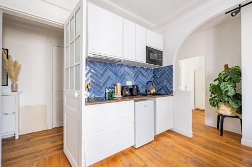une cuisine avec des placards blancs et un comptoir dans l'établissement Apartment 2 Bedrooms#2 Bathrooms#Paris 14#Alesia, à Paris
