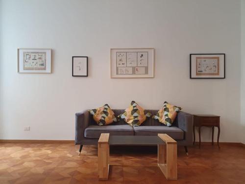 a living room with a couch and paintings on the wall at L'Arco Trieste studio living 1 in Trieste