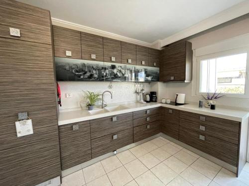 a kitchen with wooden cabinets and a sink at La Famiglia Appartment in Perea
