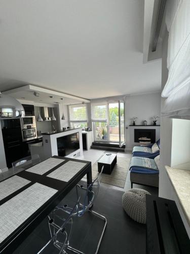 eine Küche und ein Wohnzimmer mit Tisch und Stühlen in der Unterkunft Nord House Apartament in Jastrzębia Góra