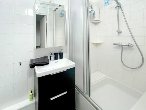 une salle de bain avec un lavabo et une douche dans l'établissement Les pieds dans l'eau / F2 avec vue sur Mer, à Houlgate