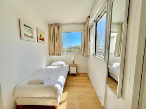 une chambre avec un lit et une grande fenêtre dans l'établissement PGH N33 - Centre-Ville, Port & Plage à 100m, à La Grande Motte