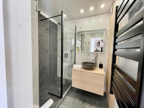 une salle de bain avec une douche en verre et un lavabo dans l'établissement PGH N33 - Centre-Ville, Port & Plage à 100m, à La Grande Motte