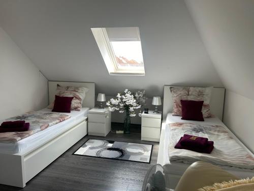 a attic room with two beds and a vase of flowers at Wolfenbüttler Apartment in Wolfenbüttel