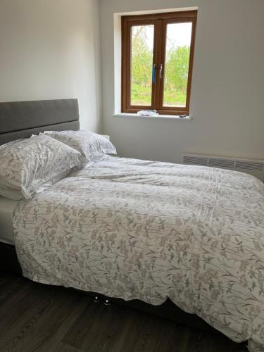 Bett in einem weißen Schlafzimmer mit Fenster in der Unterkunft The Chequers in Downham Market