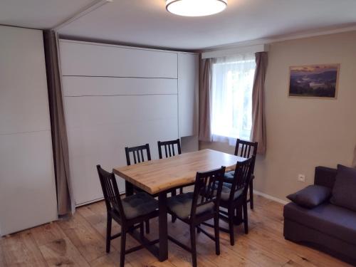 a dining room with a table and chairs and a couch at Nad rybníkem Hnačov - rodinný rekreační areál in Hnačov