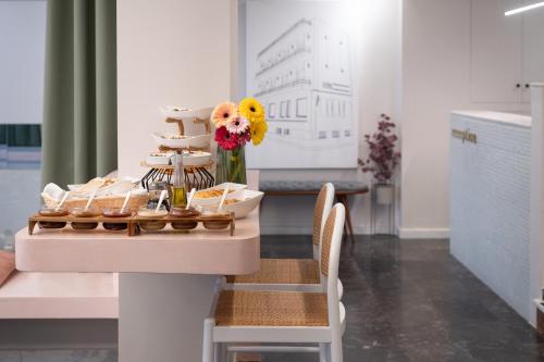 a table with shoes and a vase of flowers on it at IRA - ΗΡΑ Hotel in Kalamata