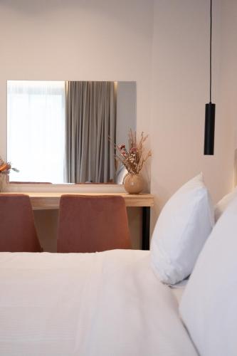 a bedroom with a bed and a window and a table at IRA - ΗΡΑ Hotel in Kalamata