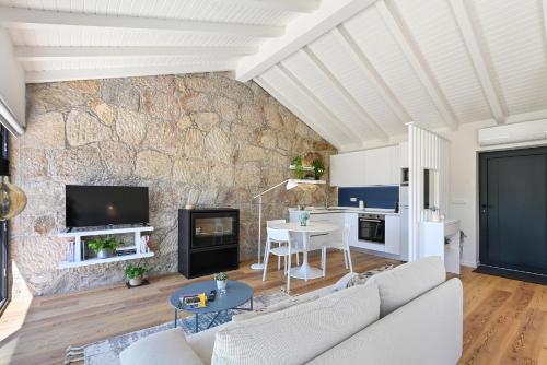 a living room with a couch and a stone wall at Casas das Olas in Arcos de Valdevez