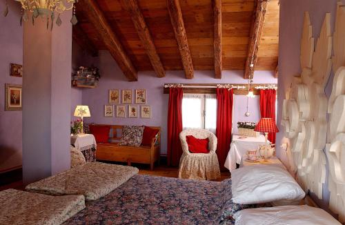 a bedroom with red curtains and a bed and a chair at Maso Di Villa Relais Di Campagna in Susegana