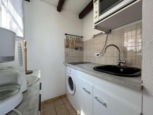 une salle de bain avec un lavabo et une machine à laver dans l'établissement Studio mezzanine avec terrasse, 4 couchages, proximité commerces et plage, parking privé - FR-1-229-840, à Gruissan