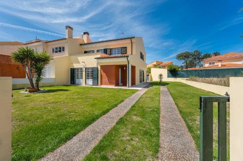 a large house with a green lawn in front of it at GuestReady - Peaceful Escape in Praia de Mira in Praia de Mira