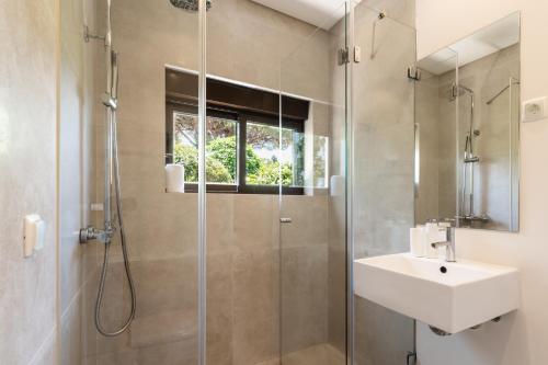 a bathroom with a sink and a shower at Vila Hibisco by Garvetur in Vilamoura