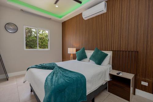 Schlafzimmer mit einem Bett mit grüner Decke in der Unterkunft Guanaco House, Hot water, Wifi, Air conditioning , prime location ,Sinai in Santa Ana