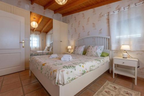 ein Schlafzimmer mit einem weißen Bett und einem Fenster in der Unterkunft Apartamento Hibisco: Jacuzzi y Vistas al Atlántico in Adeje