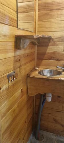 La salle de bains en bois est pourvue d'un lavabo et d'un miroir. dans l'établissement Roulotte avec piscine la jonquille, à Valgorge