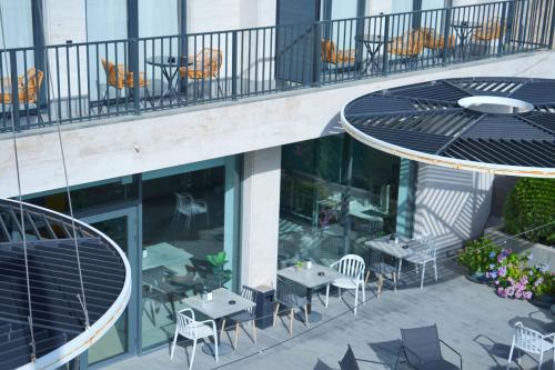 uma varanda com mesas e cadeiras num edifício em 4Guest Hotel em Yerevan