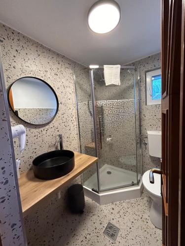 a bathroom with a sink and a shower with a mirror at Casa Mia in Moieciu de Sus