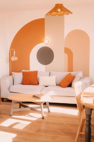 a living room with a white couch and a table at Appart Familial, prox Gare & Centre-ville, garage in Besançon