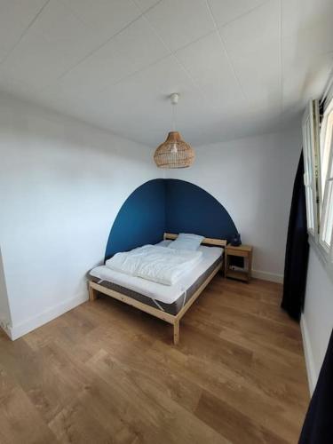 a bedroom with a bed with a blue headboard at Appart Familial, prox Gare & Centre-ville, garage in Besançon