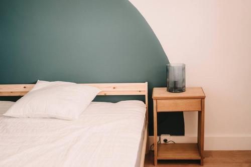 a bedroom with a bed and a nightstand with a white bed sidx sidx sidx at Appart Familial, prox Gare & Centre-ville, garage in Besançon