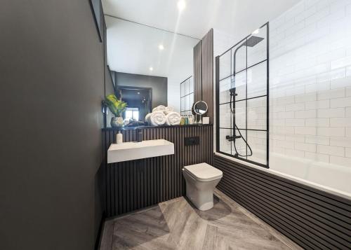 a bathroom with a toilet and a sink at The Bells - Luxury Serviced Apartments in Leeds