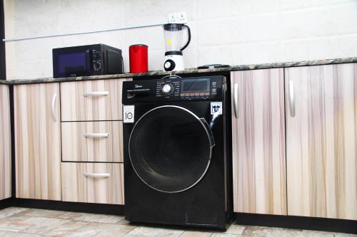 a black washing machine sitting next to a counter at Pearl Exquisite Apartments in Lekki