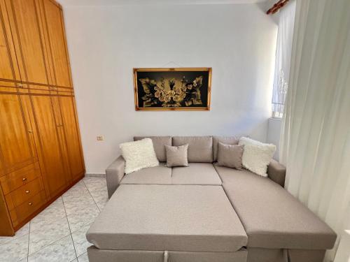 a living room with a couch and a painting on the wall at Graci Apartments in Sarandë