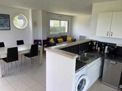 Il comprend une cuisine et un salon avec un évier et un comptoir. dans l'établissement Appartement avec terrasse, WIFI à 100m de la plage à Trébeurden - FR-1-368-424, à Trébeurden