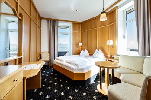 um quarto de hotel com uma cama e uma cadeira em Sporthotel am Semmering em Semmering
