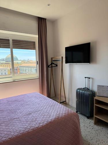 a hotel room with a bed and a flat screen tv at Incoming Municipio in Naples