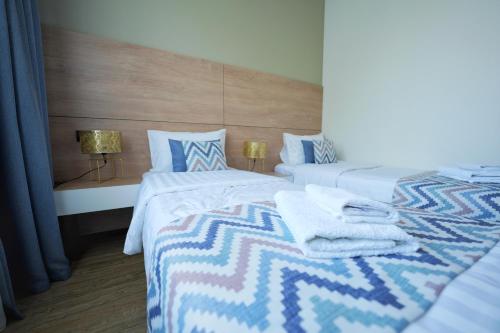 a bedroom with two beds with towels on them at 4Guest Hotel in Yerevan