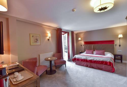 um quarto de hotel com uma cama, uma mesa e cadeiras em Hôtel Golf Château de Chailly em Chailly-sur-Armançon