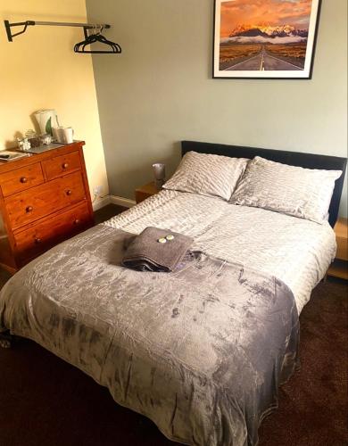 a bedroom with a large bed with a dresser and a dresser at The Plough in Sleights