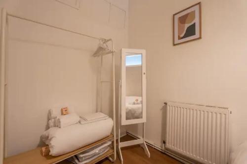 Cette chambre blanche comprend un lit et un miroir. dans l'établissement Super appartement - centre-ville Mulhouse 4pers, à Mulhouse