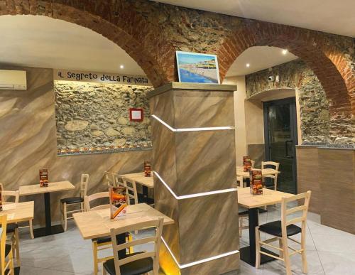 un ristorante con tavoli in legno e un muro di pietra di Lovely homes a Genova