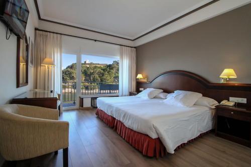una camera d'albergo con un letto e una grande finestra di Silken Gran Hotel del Sella a Ribadesella