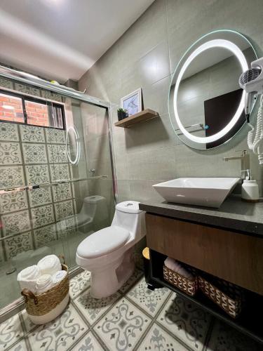 a bathroom with a toilet and a sink and a mirror at Tinta & hierro suite 1 in Loja