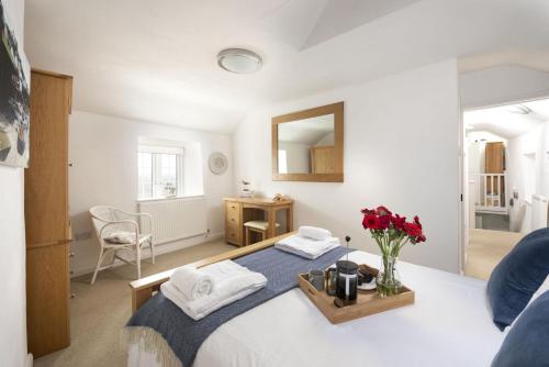 ein Schlafzimmer mit einem Bett mit einer Blumenvase in der Unterkunft Dolor Cottage in Coverack