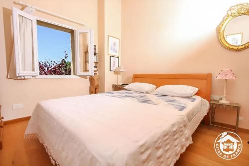 une chambre avec un lit blanc avec une fenêtre dans l'établissement Le Mas de la Font de l'Aube, à Mérindol-les-Oliviers