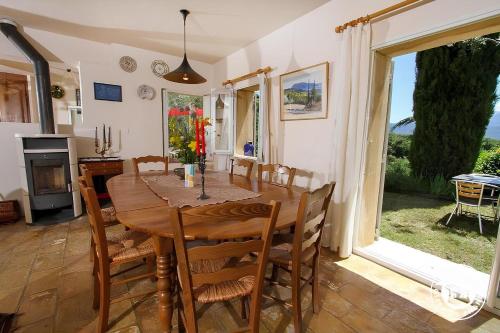 une salle à manger avec une table et des chaises en bois dans l'établissement Le Mas de la Font de l'Aube, à Mérindol-les-Oliviers