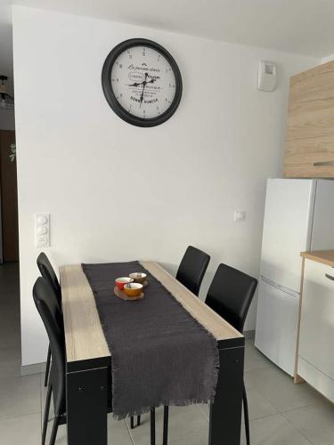 une table à manger avec une horloge sur le mur dans l'établissement le Natural, à Thonon-les-Bains