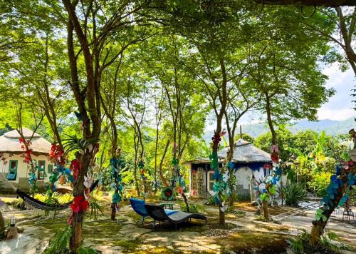 a garden with a hammock and a house and trees at Clay House Chiang Mai By Alphatel in Chiang Mai