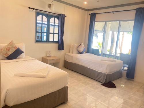 a bedroom with two beds and a window at Sunset Beach Villas in Haad Rin